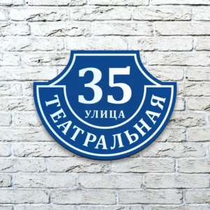 Домовой знак из композита "Ретро-классика" синего цвета на белой кирпичной стене.