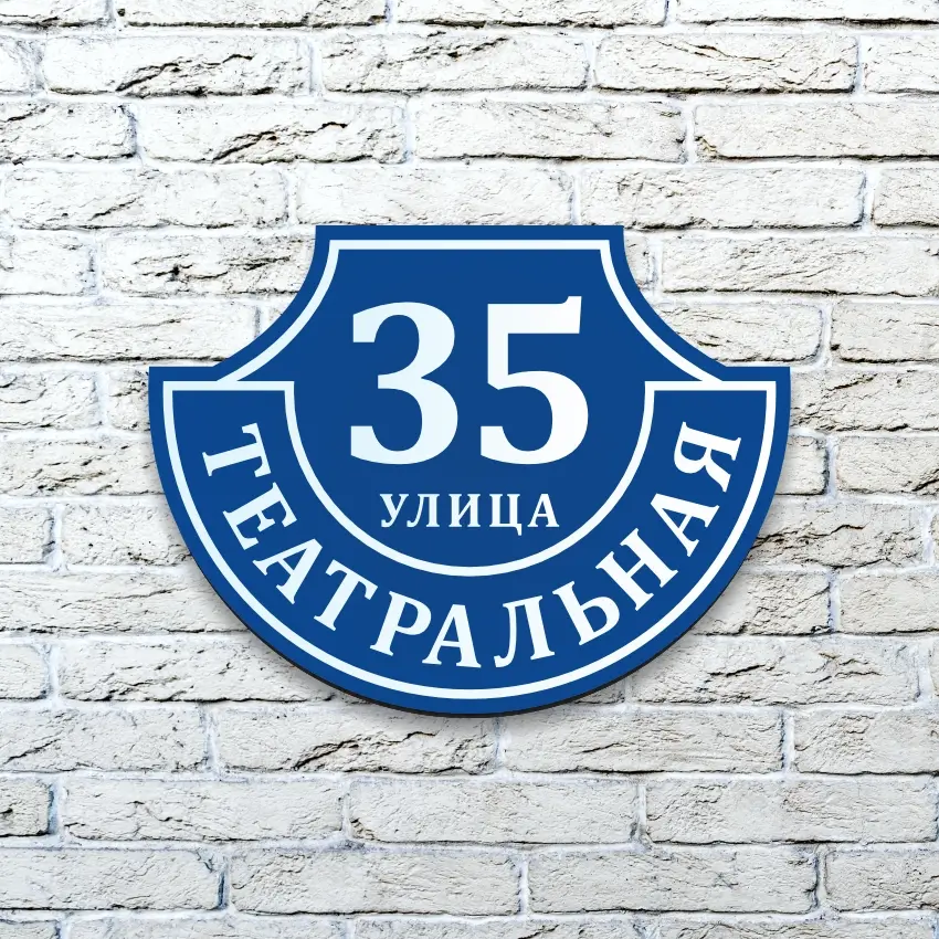 Домовой знак из композита "Ретро-классика" синего цвета на белой кирпичной стене.